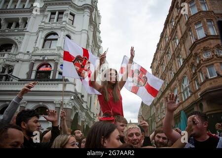 Una giovane donna festeggia mentre i tifosi inglesi si riuniscono su Leicester Square davanti alla finale Euro 2020 Inghilterra contro Italia. Foto Stock