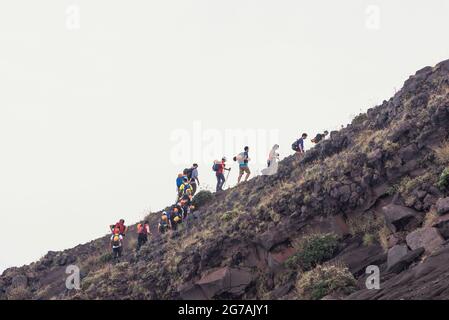 Persone trekking fino alla cima del vulcano Stromboli, Stromboli, Isole Eolie, Sicilia, Italia Foto Stock