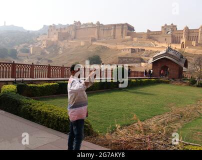 I turisti scattano foto al famoso Forte Amber a Jaipur, India Foto Stock