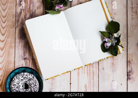 Apri il notebook su sfondo di legno. Album di disegno vuoto, scrittura di idee, progettazione, ufficio domestico, freelance, illustrazione. Foto di alta qualità Foto Stock