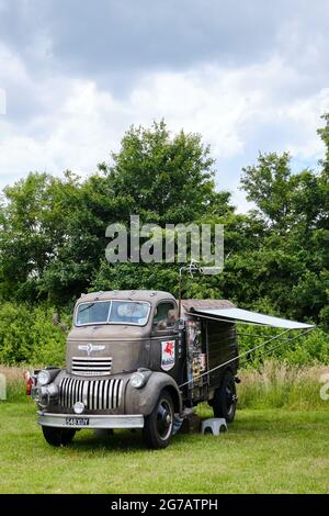 La cabina COE Chevrolet vintage sopra il camion del motore convertito usando una scatola del cavallo in un camper in un campo Foto Stock