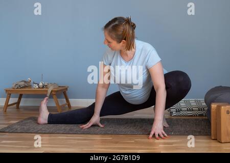Donna caucasica incinta in piedi in yoga asana Foto Stock