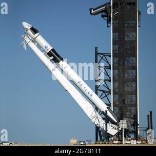 Un razzo SpaceX Falcon 9 con la navicella spaziale Crew Dragon a bordo dell'azienda è visto come è sollevato in posizione verticale sul trampolino di lancio per l'imminente missione Demo-2, il 21 maggio 2020. Kennedy Space Center, Florida, USA. La missione SpaceX Demo-2 della NASA è il primo lancio con gli astronauti della navicella spaziale SpaceX Crew Dragon e il razzo Falcon 9 alla Stazione spaziale Internazionale. Una versione unica, ottimizzata e potenziata digitalmente di un'immagine della NASA da parte del fotografo senior della NASA Bill Ingalis / Credit NASA Foto Stock