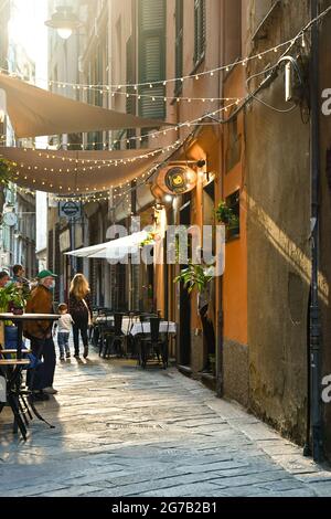 Scorcio di Via di San Bernardo, un vicolo stretto (carrugio) nel centro medievale con gente, Genova, Liguria, Italia Foto Stock
