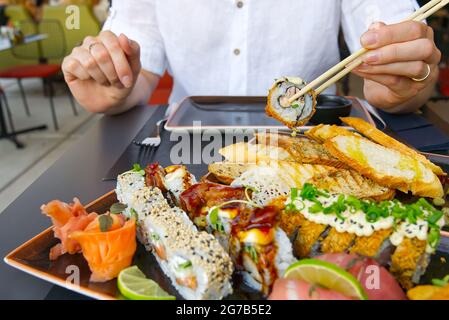 mangiare sushi con chopsticks al ristorante sushi Foto Stock