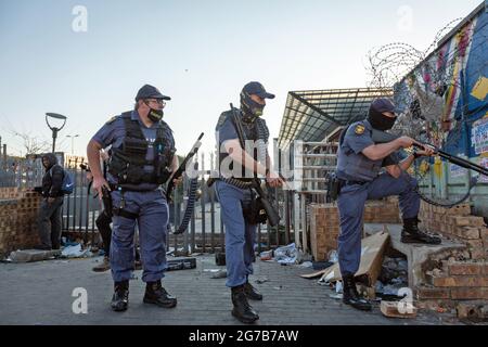 (210712) -- JOHANNESBURG, 12 luglio 2021 (Xinhua) -- gli ufficiali di polizia sono posizionati per occuparsi del saccheggio a Johannesburg, Sudafrica, il 12 luglio 2021. Lunedì scorso l'esercito sudafricano ha affermato che i soldati sono stati dispiegati nelle province di KwaZulu-Natal e Gauteng per affrontare violente proteste e saccheggi. La polizia ha detto che sei persone sono state uccise e 219 persone sono state arrestate durante il fine settimana a Gauteng e KwaZulu-Natal a seguito di violente proteste dopo che l'ex presidente Jacob Zuma è stato incarcerato per 15 mesi per disprezzo della corte. Centinaia di negozi e aziende nelle due province sono state saccheggiate. (Foto di Sì Foto Stock