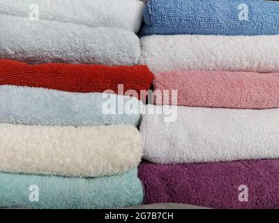 Gli asciugamani in spugna di cotone multicolore sono impilati Foto Stock
