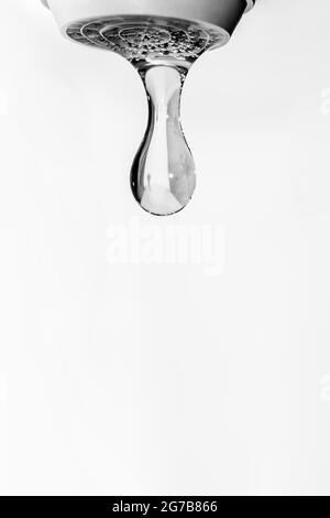 Gocce d'acqua cristallina che cadono dal rubinetto. Fotografia in bianco e nero. Foto Stock