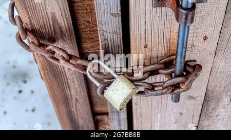 Porta per bagno esterna in legno a catena Pano con lucchetto a combinazione con lungo grillo Foto Stock