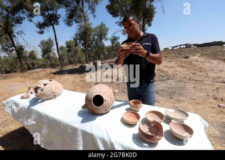 Kiryat Gat, Israele. 12 luglio 2021. Un archeologo israeliano lavora presso il sito archeologico Khirbet ar-Ra'i vicino a Kiryat Gat, Israele meridionale, il 12 luglio 2021. Gli archeologi israeliani e australiani hanno scoperto una caraffa in ceramica con una rara iscrizione biblica nel sud di Israele, che risale a 3,100 anni fa, ha detto lunedì l'autorità israeliana delle Antichità (IAA). Credit: Gil Cohen Magen/Xinhua/Alamy Live News Foto Stock