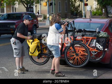 Due ciclisti scaricano le loro biciclette elettriche mentre si preparano ad esplorare Santa Fe, New Mexico. Foto Stock