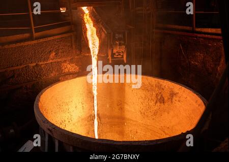 Spillatura di scorie di altoforno. La scoria fusa viene versata in una siviera. Foto Stock