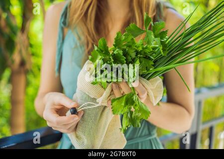 Verdure fresche in una borsa riutilizzabile nelle mani di una giovane donna. Concetto di zero sprechi Foto Stock