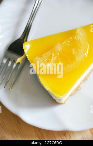 Sopra di crostata di formaggio di limone su piatto bianco con forchetta Foto Stock