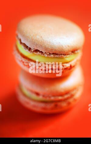 Macaron aromatizzati allo zafferano su sfondo arancione. Realizzato da Les Macarons de PIM! Foto Stock