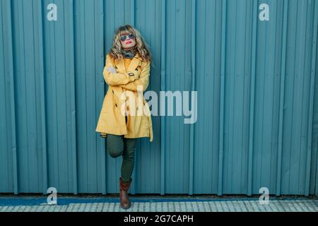 bella donna sulla strada in impermeabile alla moda Foto Stock