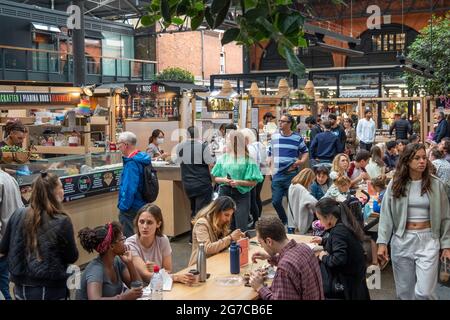 Londra - Luglio 2021: Bancarelle di cibo all'interno del mercato di Spitalfields. Un mercato popolare con cibo, bar, arte e artigianato Foto Stock