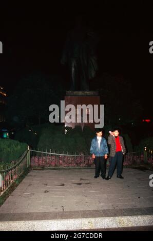 Zwei Chinesen vor dem Denkmal von Chen Yi, dem ersten komminstischen Bürgermeister von Shanghai, bei Nacht, Cina 1998. Due cinesi di fronte a Yen Yi, primo sindaco comunista di Shanghai, Cina 1998. Foto Stock