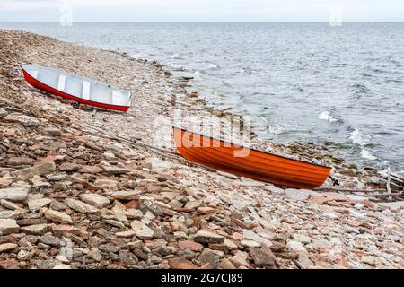 Barche a remi tirate su una spiaggia vicino al mare Foto Stock