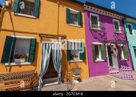 Vecchie piccole e belle case multicolore (colori brillanti) nell'isola di Burano in una soleggiata giornata di primavera. Venezia, Veneto, Italia, Europa. Foto Stock