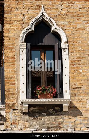 Primo piano di un'antica finestra con arco in stile gotico veneziano sull'isola di Murano, laguna di Venezia, patrimonio dell'umanità dell'UNESCO, Veneto, Italia, Europa. Foto Stock