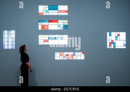 Una persona vede la composizione geometrica verticale-orizzontale (vetrate per l'appartamento di Andre Horn, Strasburgo) 1928 durante una telefonata per la nuova mostra Sophie Taeuber-Arp al Tate Modern di Londra. Data immagine: Martedì 13 luglio 2021. Foto Stock