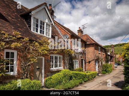 Regno Unito, Inghilterra, Buckinghamshire, Hambleden Valley, Turville, School Lane, Wisteria in fiore al di fuori di mattoni e selce costruito Belle Cottage Foto Stock