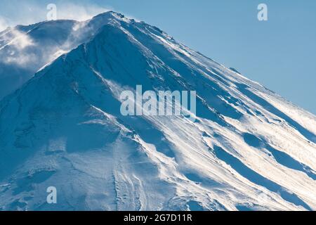 Cima ghiacciata innevata del Monte Fuji. La montagna più alta del Giappone e vulcano attivo. Venti che soffiano neve dalla cima della montagna. Foto Stock