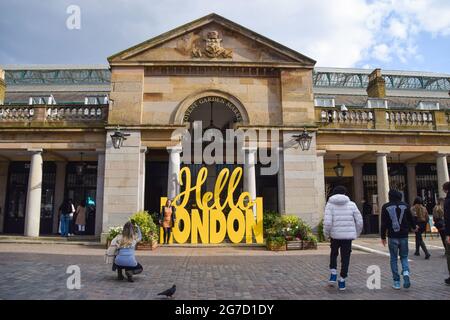 La gente cammina oltre l'insegna Hello London a Covent Garden Market. Londra, Regno Unito, aprile 2021. Foto Stock