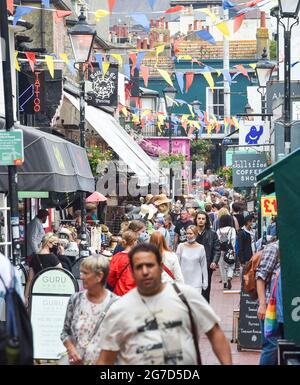 Brighton UK 13 luglio 2021 - il distretto del Laine del nord di Brighton è occupato con i clienti oggi come Brighton e Hove è stato dichiarato una "zona di risposta migliorata" della città a seguito di un aumento allarmante nei casi di Covid-19, in particolare della variante di Delta. il consiglio della città è di ricevere ulteriore aiuto e sostegno da parte del governo Che aumenterebbe i test e garantire che la città può rimanere sicura e aperta per il business come il prossimo allentamento delle restrizioni inizierà Lunedi prossimo .: Credit Simon Dack / Alamy Live News Foto Stock