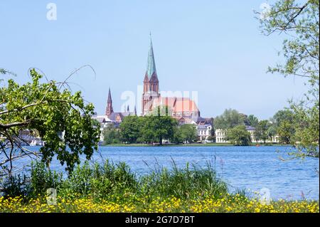Cattedrale di Schwerin St. Marien e St. Johannis, uno dei primi grandi esempi di architettura gotica in mattoni, visto dalla riva del lago nello stato Foto Stock
