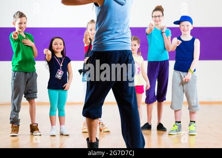 Insegnante di danza dare ai bambini lezione di fitness in palestra Foto Stock