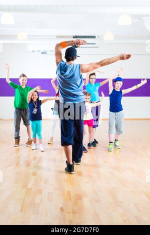 Insegnante di danza dare ai bambini lezione di fitness in palestra Foto Stock