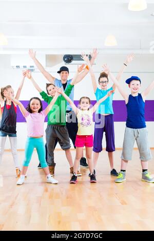 Insegnante di danza dare ai bambini Zumba Fitness classe in palestra Foto Stock