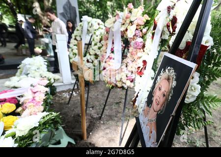 13 luglio 2021, Ungheria, Budapest: Una foto della diva di Hollywood Zsa Zsa Gabor e delle corone di fiori stanno alla sua urna sepoltura nella tomba d'onore nel cimitero di Kerepesch. Più di quattro anni dopo la sua morte, il principe aveva portato la sua urna dagli Stati Uniti a Budapest. Foto: Csaba Doemoetoer/dpa Foto Stock