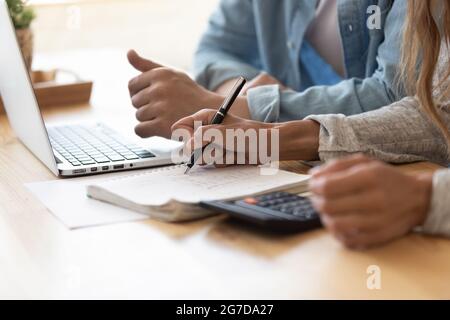 Primo piano i coniugi che calcolano il budget della famiglia pagando online utilizzando il laptop Foto Stock