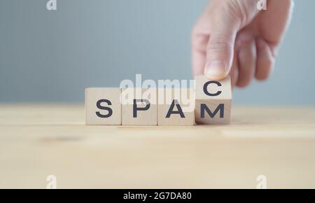 Società di acquisizione per scopi speciali. La mano dell'investitore flip legno cubo cambiare la parola, SPAC o SPAM su tavola di legno e sfondo grigio. Stimolare lo stock Foto Stock