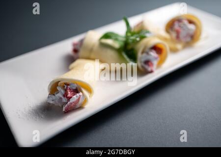 panini sottili con formaggio cremoso e fragola su sfondo nero Foto Stock