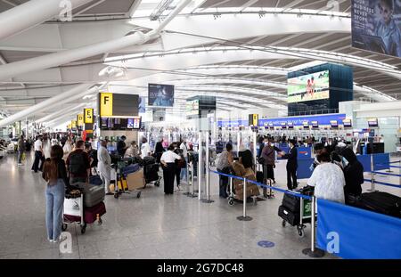 Londra, Regno Unito. 13 luglio 2021. Passeggeri al Terminal 5. I passeggeri di Heathrow si avvicinano il 19 luglio e le restrizioni di viaggio saranno revocate in alcuni paesi. Ieri (12 luglio) ci sono state lunghe code a Heathrow come un sacco di guardie di sicurezza ha dovuto autoisolare. L'Unione dei servizi di immigrazione ha avvertito che i viaggiatori possono affrontare fino a 6 ore di ritardo quando le restrizioni sono attenuate. Credit: Mark Thomas/Alamy Live News Foto Stock