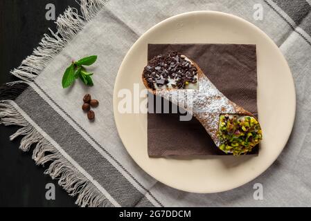 cannoli siciliani dolci ripieni di ricotta e zucchero con pistacchi e gocce di cioccolato Foto Stock