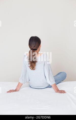 Vista posteriore di una donna che guarda a un muro Foto Stock