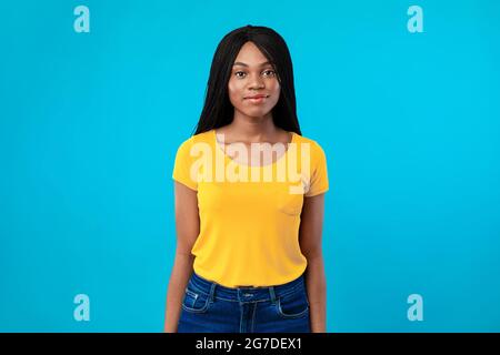 Donna afroamericana con capelli intrecciati che posano su sfondo blu Foto Stock