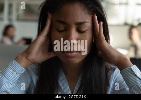 Stressato misto corsa nero dipendente ufficio che soffre di mal di testa Foto Stock