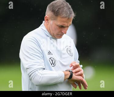 13 luglio 2021, Hessen, Francoforte sul meno: Stefan Kuntz, capo allenatore della squadra di calcio olimpica, guarda l'orologio durante l'allenamento finale allo stadio di Francoforte. Il torneo olimpico di calcio di Tokyo si svolgerà dal 22 luglio al 7 agosto. Foto: Arne Dedert/dpa Foto Stock