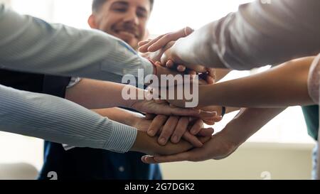 I membri del team aziendale, i dipendenti degli uffici della millenaria mettono insieme le mani Foto Stock