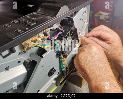 Primo piano delle mani di un tecnico che ripara la stampante Foto Stock