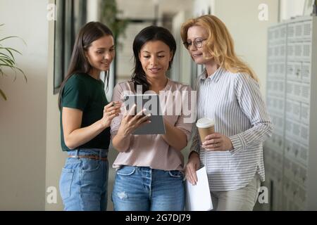 Dipendente misto che mostra un progetto di progettazione virtuale ai colleghi Foto Stock