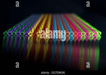 Concetto astratto di arte geometrica di cannucce colorate riflesse su superficie nera Foto Stock