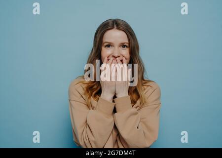 Ragazza teenage sorpresa che copre la bocca con le mani Foto Stock