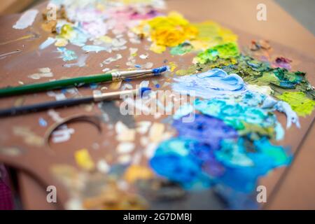 Palette con pitture e pennelli multicolore, foto di pittura femminile Foto Stock